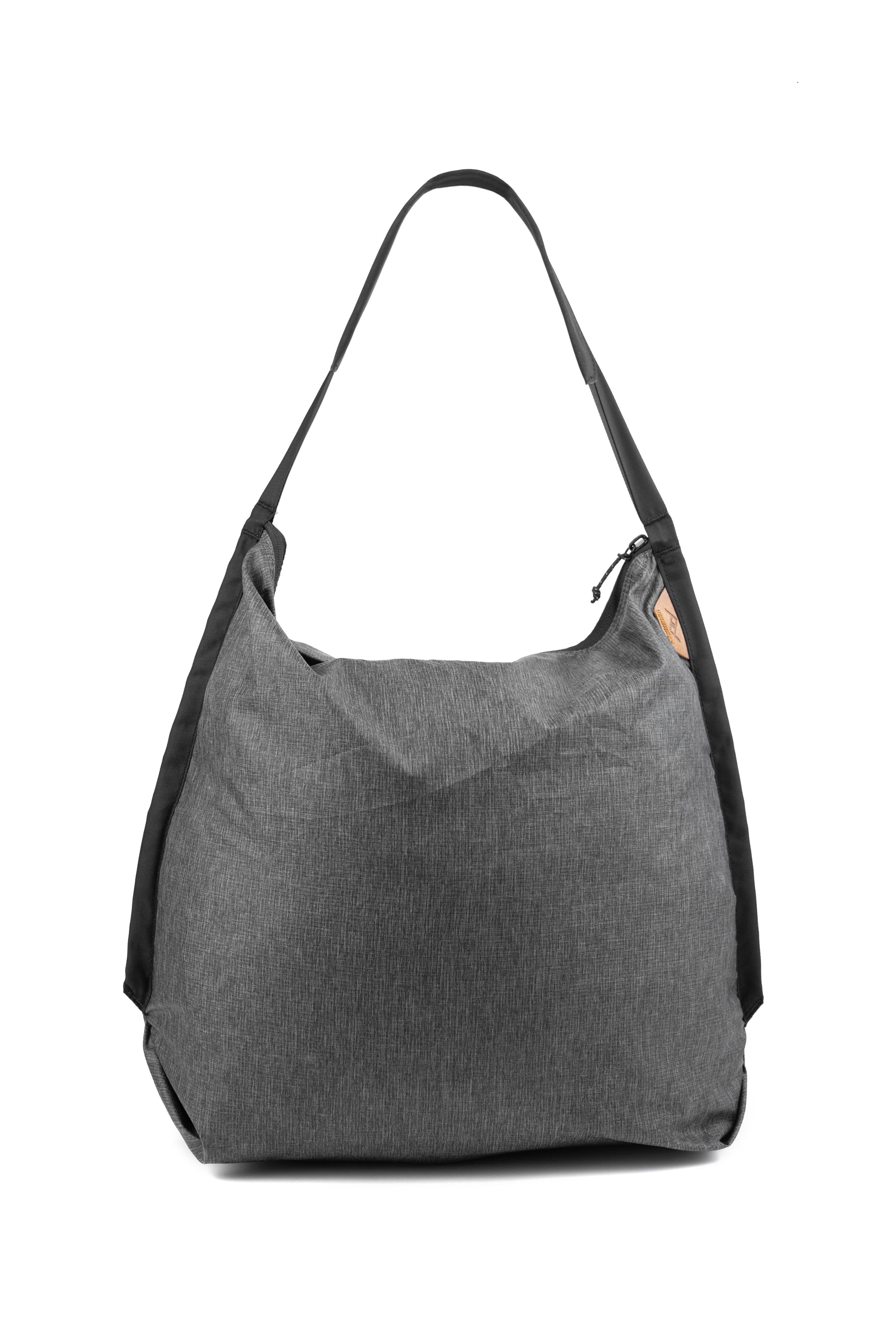 'Peak Design Packable Tote in Charcoal color on a travel background'